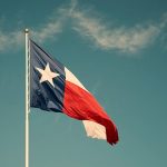 State flag of Texas against blue sky. Vintage filter effects.
