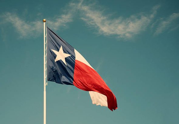 State flag of Texas against blue sky. Vintage filter effects.